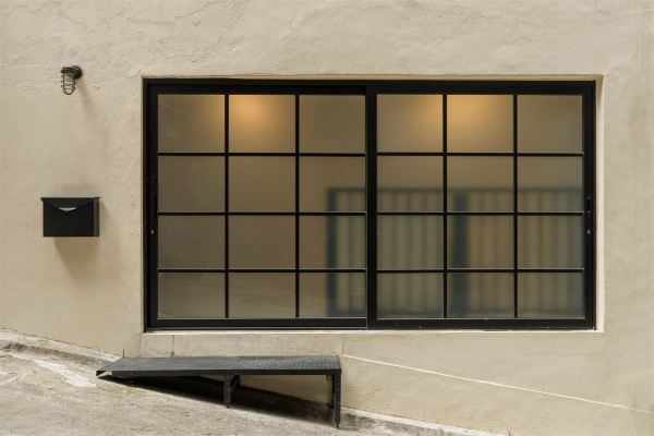Exterior facade with black steel-framed window and mailbox